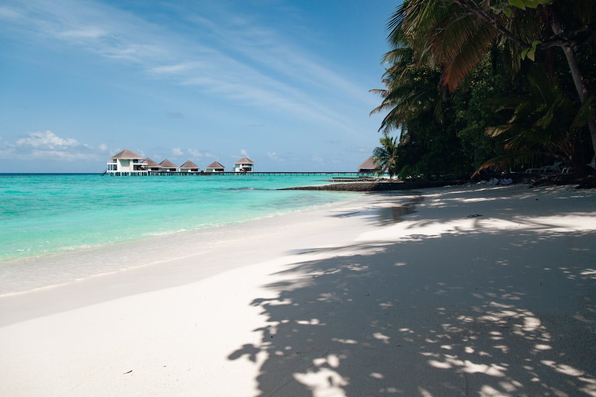 A white sand beach overlooks the private overwater villas in the Maldives