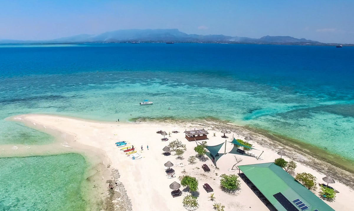 A beautiful beach and private island in Fiji seen from above.
