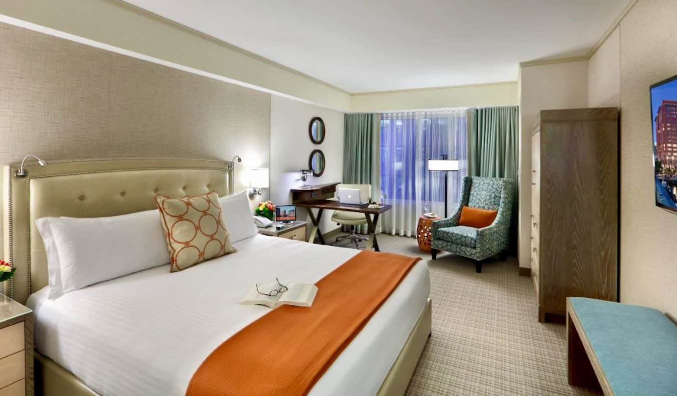 A large and stylish hotel room with a big bed and lots of furniture at the Seaport Hotel in Boston