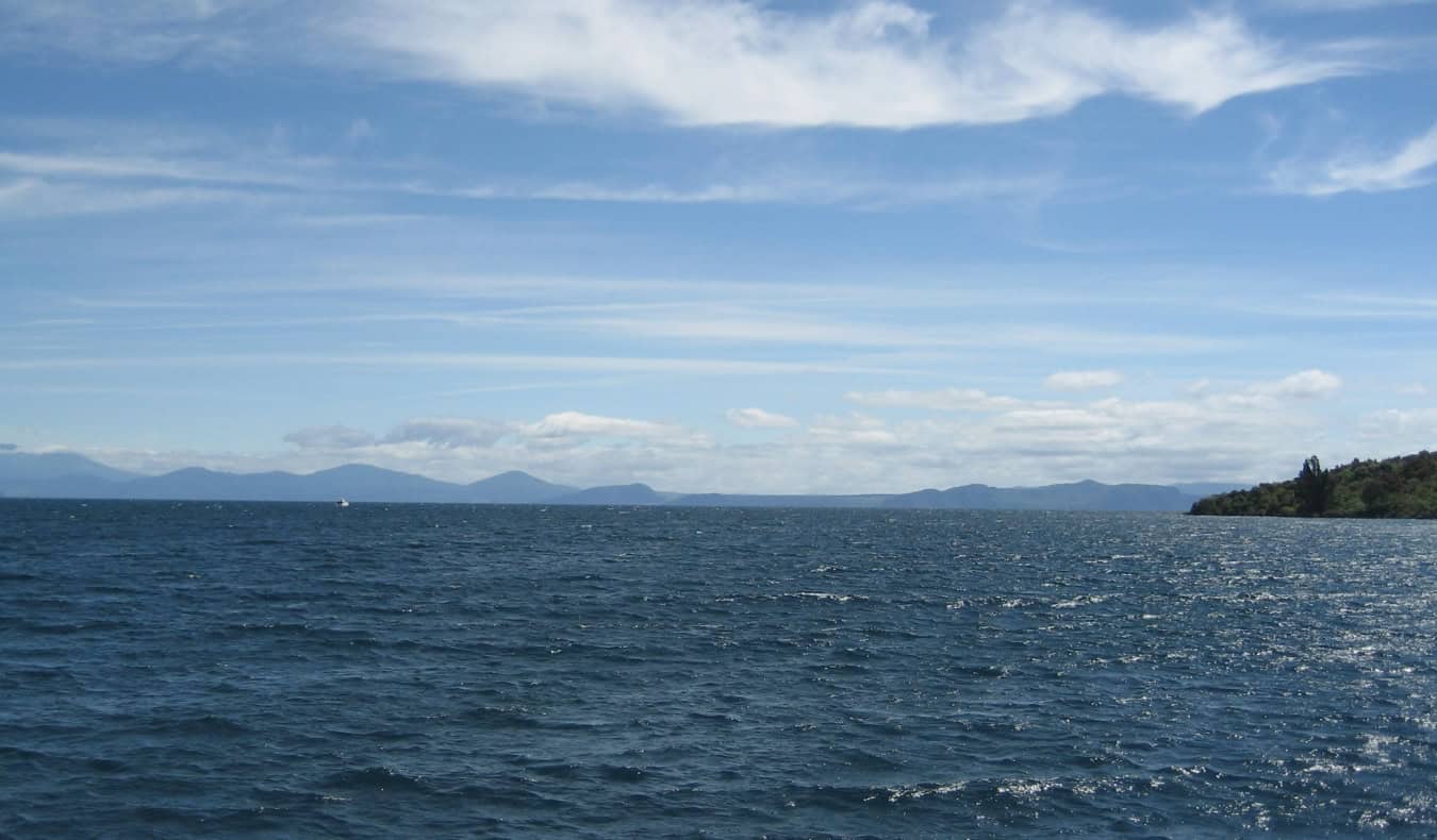 The serene lake of Taupo with mountains in the background, in New Zealand